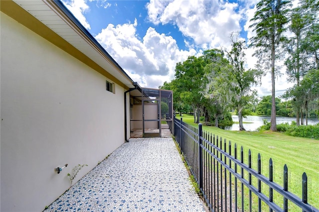 view of patio / terrace featuring a lanai and a water view