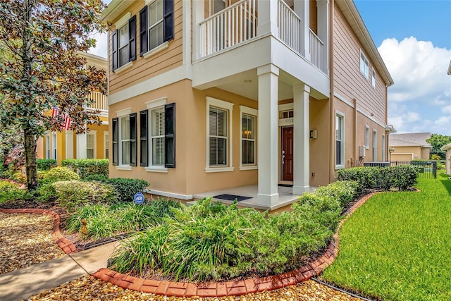 view of property exterior with a yard and a balcony