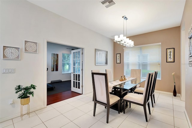 tiled dining space featuring a wealth of natural light and an inviting chandelier