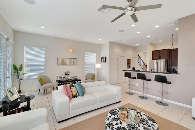 living room featuring light tile patterned flooring and ceiling fan