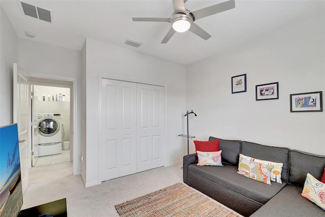 carpeted living room featuring washer / dryer and ceiling fan