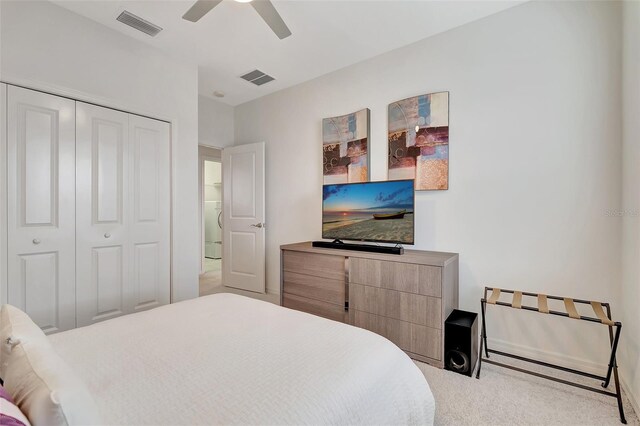 carpeted bedroom featuring a closet, ceiling fan, and washer / clothes dryer