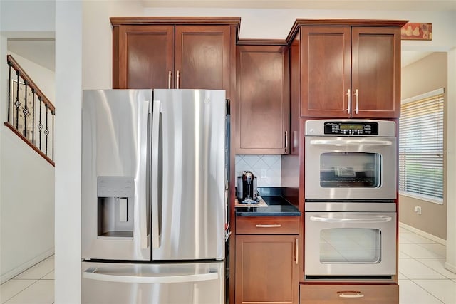 kitchen with backsplash, stainless steel appliances, and light tile patterned floors