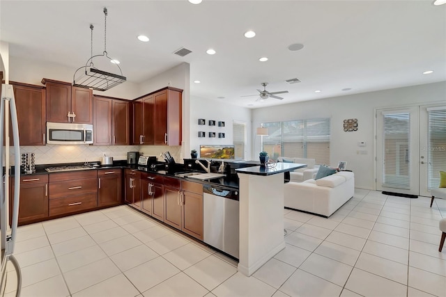 kitchen featuring appliances with stainless steel finishes, light tile patterned flooring, kitchen peninsula, ceiling fan, and pendant lighting