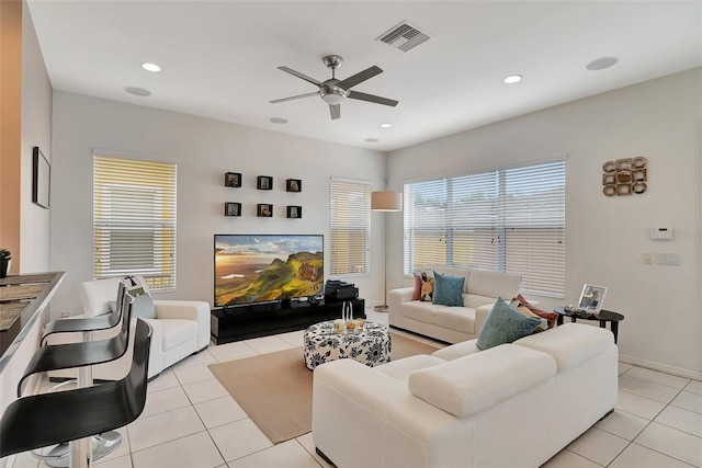 tiled living room featuring a healthy amount of sunlight and ceiling fan