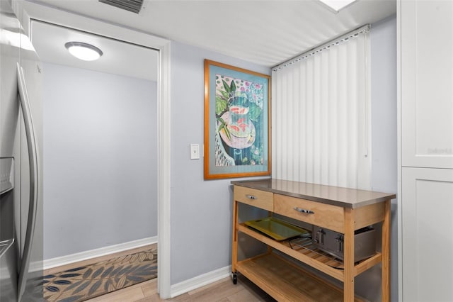 interior space with stainless steel fridge and hardwood / wood-style flooring