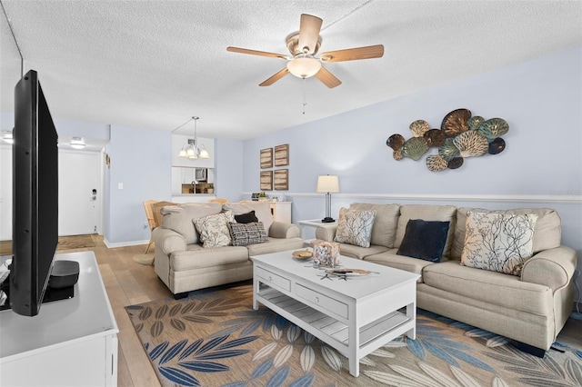 living room featuring hardwood / wood-style floors, a textured ceiling, and ceiling fan with notable chandelier