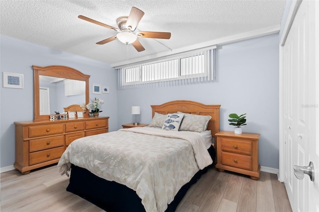 bedroom featuring ceiling fan, light hardwood / wood-style flooring, a textured ceiling, and a closet