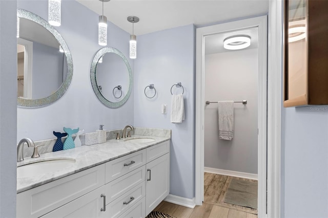 bathroom with dual vanity and hardwood / wood-style flooring