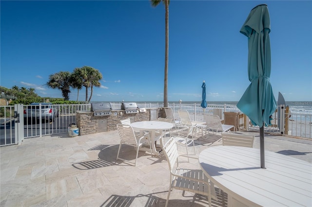 view of patio / terrace featuring a water view and an outdoor kitchen