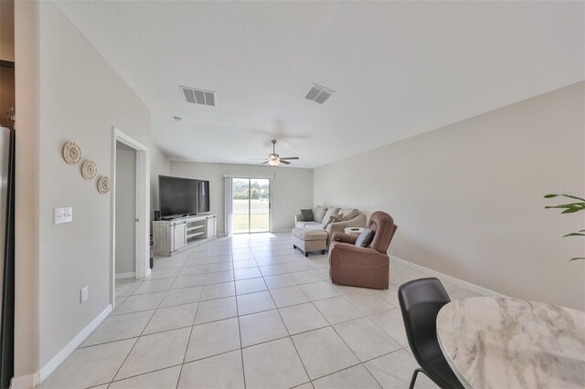 tiled living room with ceiling fan