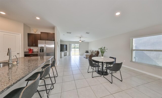 dining space featuring ceiling fan, light tile patterned flooring, and sink