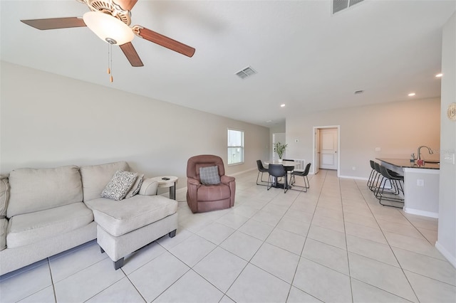 living room featuring light tile patterned floors, sink, and ceiling fan