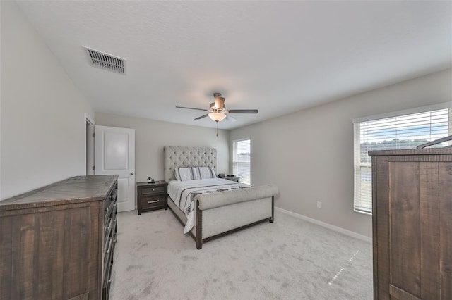 carpeted bedroom with ceiling fan and multiple windows