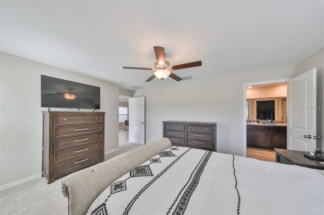 bedroom featuring connected bathroom, ceiling fan, and light carpet