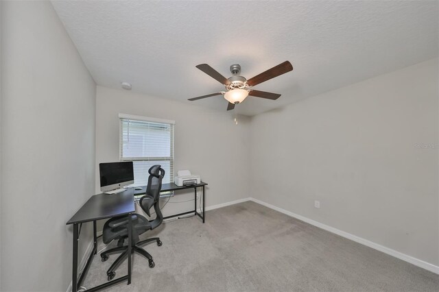 carpeted office featuring ceiling fan and a textured ceiling