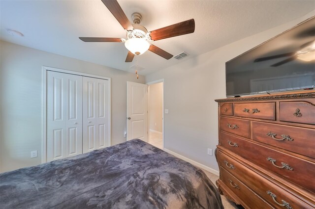 carpeted bedroom featuring a closet and ceiling fan