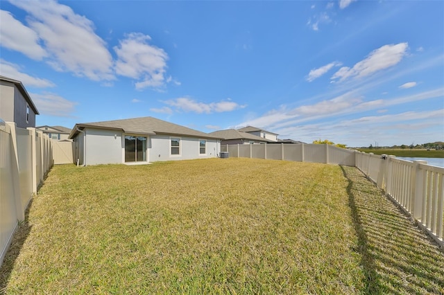 back of house featuring a yard and a water view