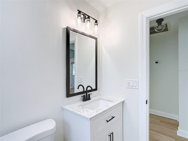 bathroom with vanity, hardwood / wood-style flooring, and toilet