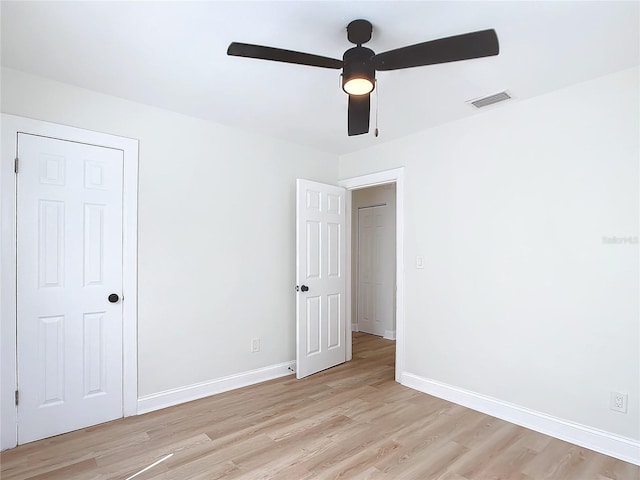 unfurnished bedroom featuring ceiling fan, a closet, and light wood-type flooring