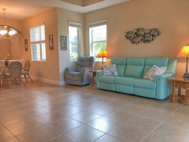 living room with plenty of natural light, a notable chandelier, and tile patterned floors