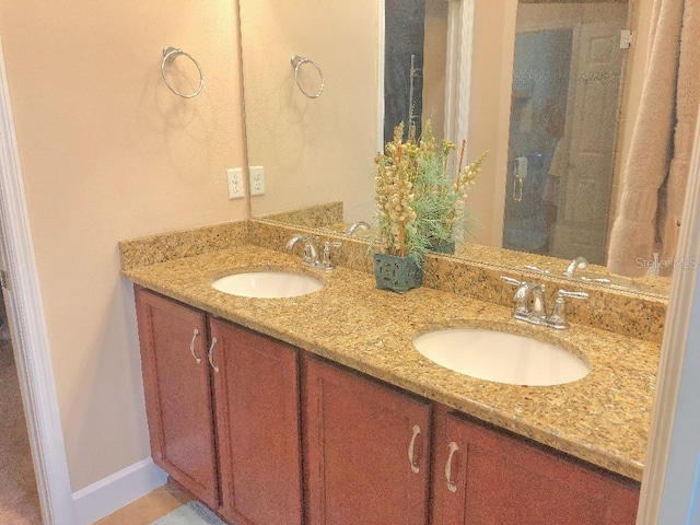 809 Chipper Dr, Sun City Center, FL 33573 - bathroom with double vanity, a sink, and baseboards