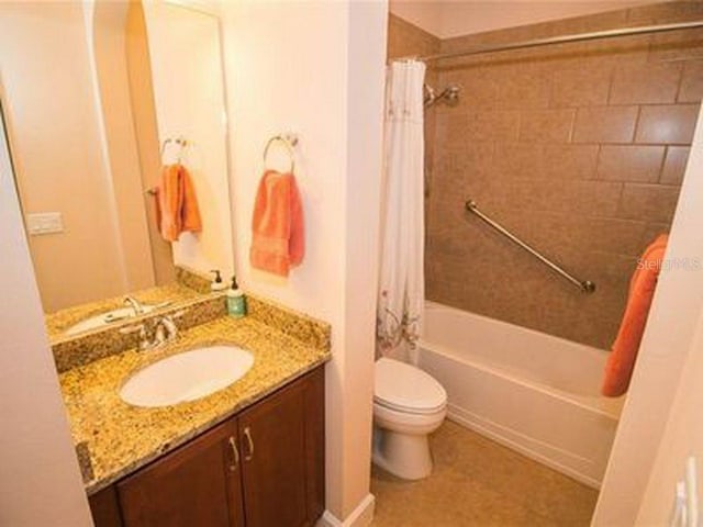 809 Chipper Dr, Sun City Center, FL 33573 - bathroom featuring shower / bath combo, vanity, and toilet