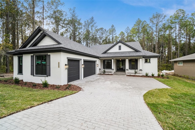 view of front facade featuring a garage, a front lawn, and covered porch