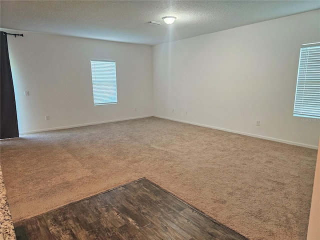 unfurnished room with hardwood / wood-style flooring and a textured ceiling