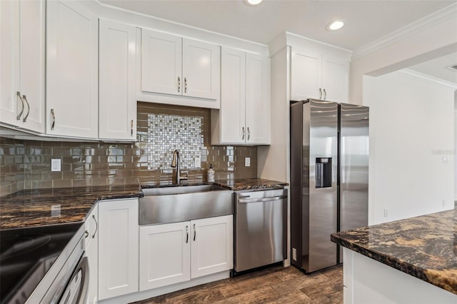 kitchen with dark stone counters, sink, hardwood / wood-style flooring, decorative backsplash, and stainless steel appliances