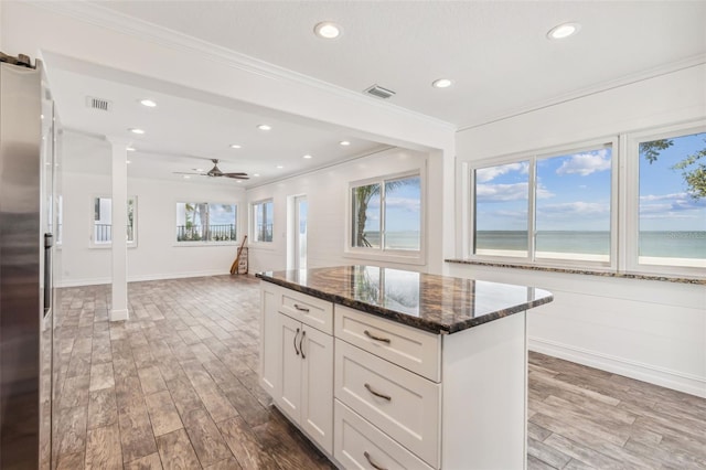 kitchen featuring dark stone counters, plenty of natural light, white cabinetry, and hardwood / wood-style floors