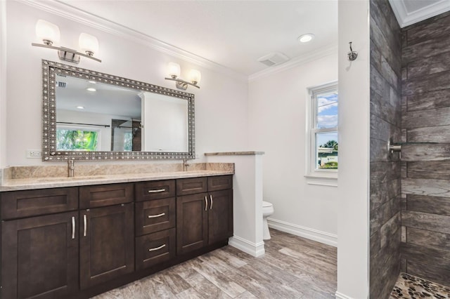 bathroom featuring ornamental molding, vanity, a shower, wood-type flooring, and toilet