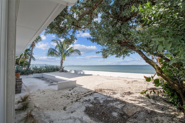 view of yard with a beach view and a water view