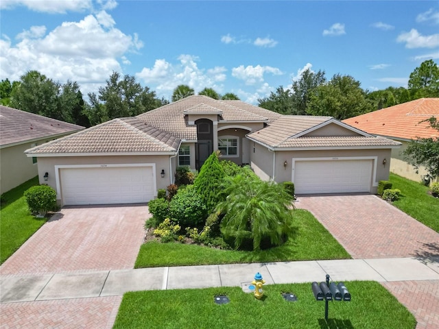 single story home featuring a garage, a tile roof, and decorative driveway