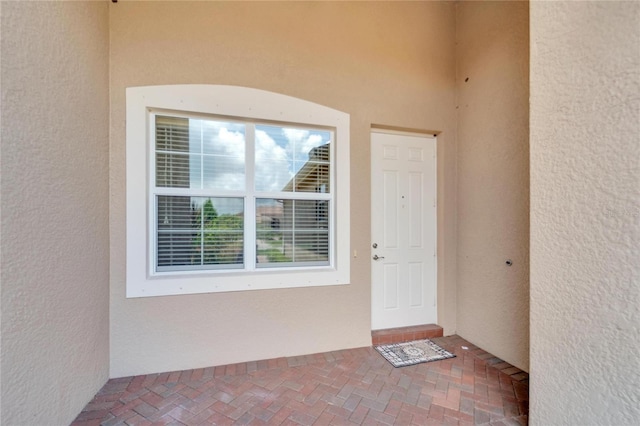 doorway to property featuring stucco siding