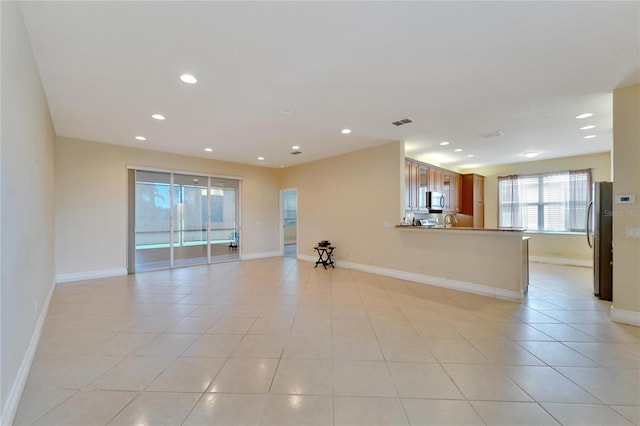 empty room featuring light tile patterned floors, baseboards, visible vents, and recessed lighting