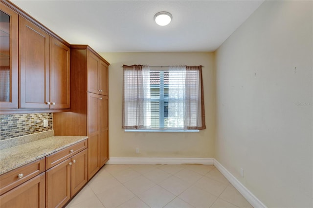 kitchen with decorative backsplash, light stone counters, and light tile patterned floors