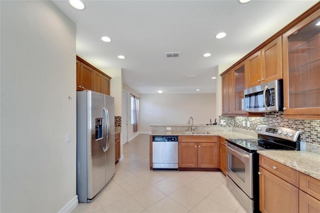 kitchen with brown cabinets, visible vents, appliances with stainless steel finishes, glass insert cabinets, and a sink