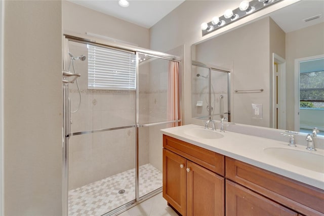 bathroom with double vanity, a sink, visible vents, and a shower stall