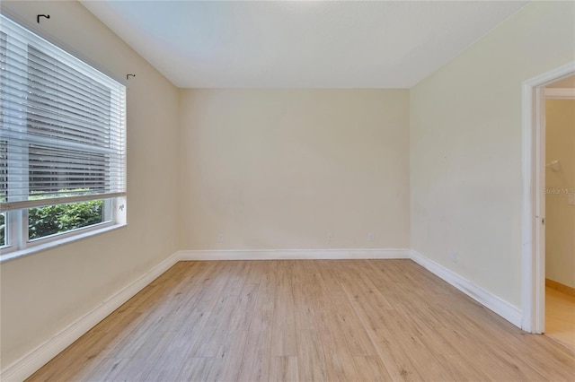 empty room with light wood-style floors and baseboards