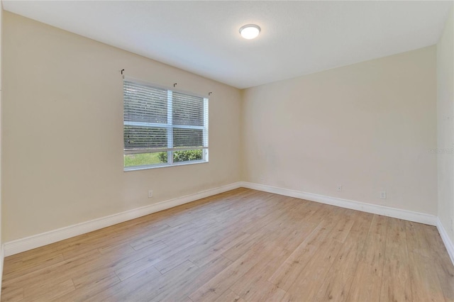 spare room with light wood-style flooring and baseboards