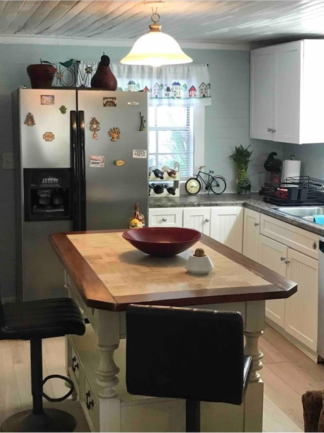 kitchen with white cabinets, stainless steel fridge with ice dispenser, butcher block countertops, white dishwasher, and pendant lighting