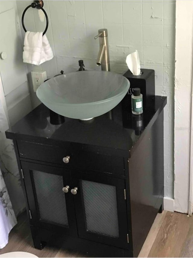 bathroom featuring tile walls, vanity, and wood finished floors