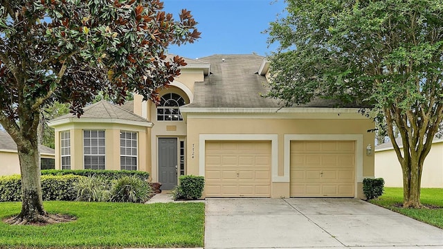 view of front of house featuring a front lawn and a garage