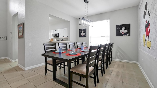 dining space with a notable chandelier and light tile patterned floors