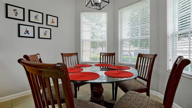 dining room with a notable chandelier and light tile patterned flooring