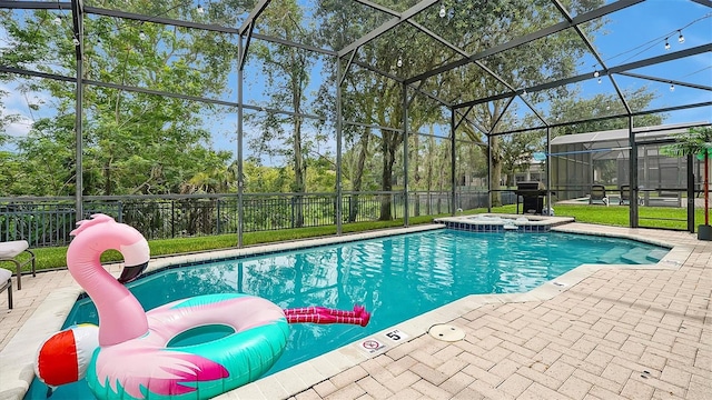 view of swimming pool featuring a patio area, glass enclosure, and an in ground hot tub