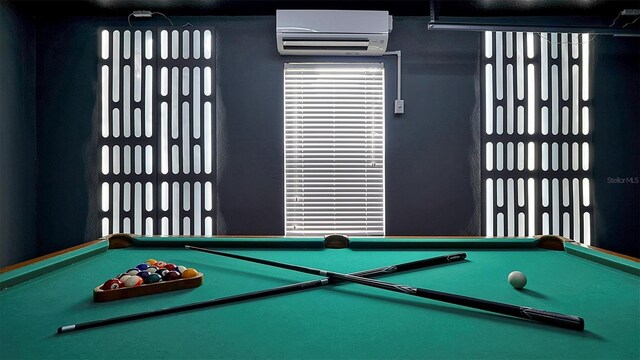 recreation room with an AC wall unit and billiards