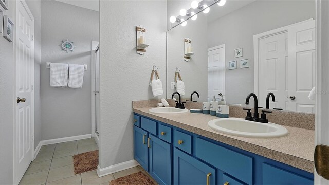 bathroom with double vanity and tile patterned flooring