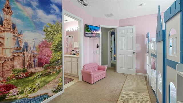 living area with sink, a textured ceiling, and light carpet